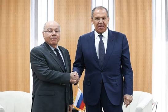 Mauro Vieira shaking hands with a counterpart beside a small Russian flag