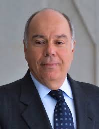 Earlier head-and-shoulders portrait of Mauro Vieira in a dark suit and patterned tie