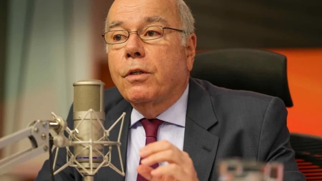 Mauro Vieira speaking into a studio microphone in a radio booth