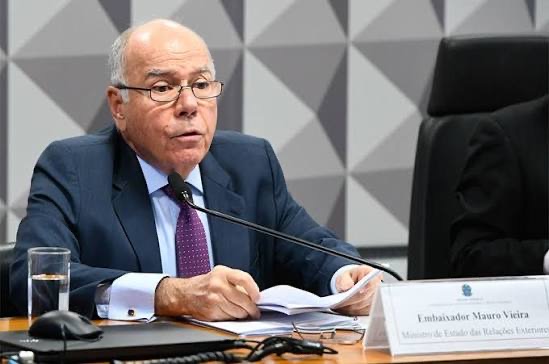 Mauro Vieira speaking at a microphone at a committee table; a nameplate reads Embaixador Mauro Vieira, Ministro de Estado das Relações Exteriores