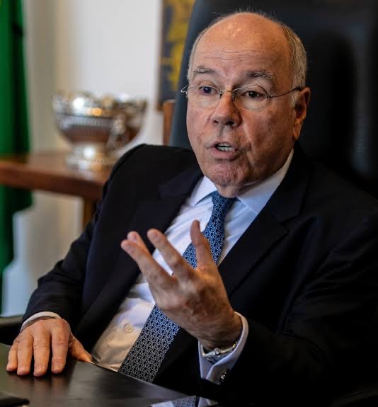 Mauro Vieira seated at a desk in his office, gesturing with his right hand while speaking